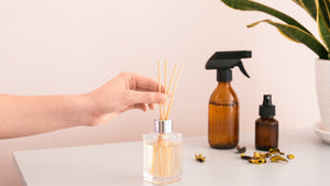someone's hand arranges a handmade reed diffuser